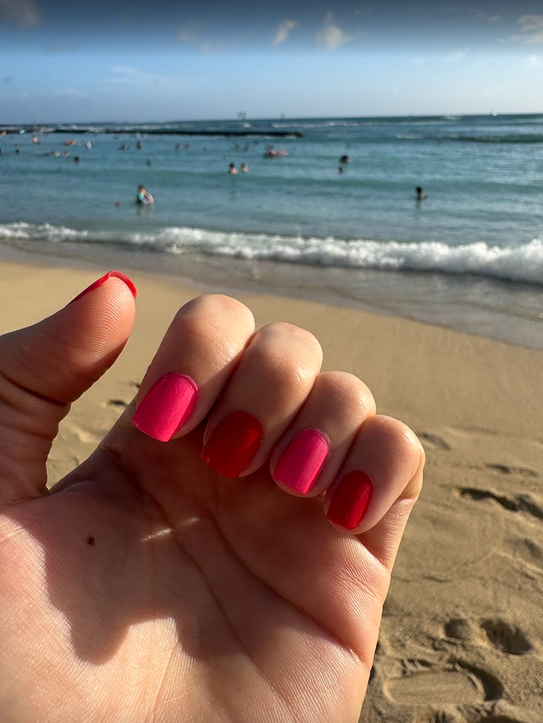 Pink and red nails at the beach