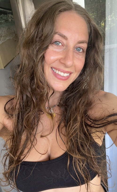 Malana smiling after a swim, wearing her shell necklace