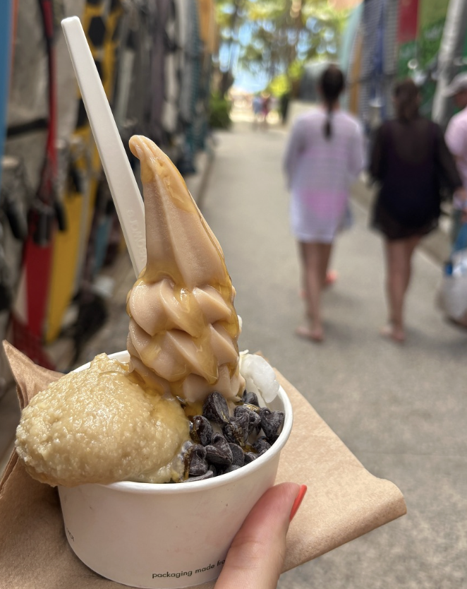 Ice cream enjoyed on a walk, held in a hand with red nails